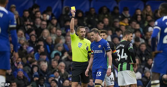 Chelsea's Conor Gallagher, right, receives a yellow card during the English Premier League soccer match between Chelsea and Brighton and Hove Albion, at Stamford Bridge stadium in London, Sunday, Dec. 3, 2023. (AP Photo/Alastair Grant)