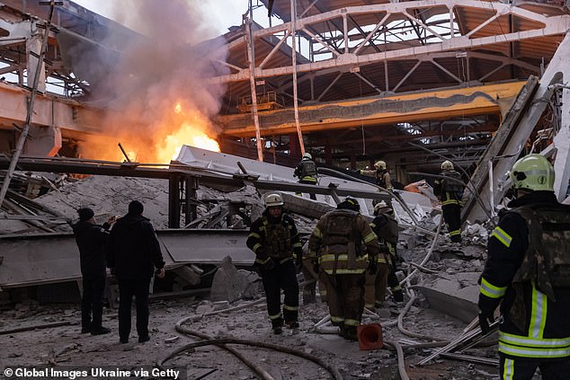Feuerwehrleute löschen am 29. Dezember 2023 nach einem russischen Raketenangriff in Charkiw, Ukraine, einen Brand in einem beschädigten Unternehmen