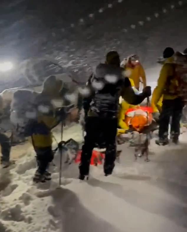 Dies ist der Moment, in dem ein Bergsteiger in einer waghalsigen Rettungsaktion von einem Bergsteigerteam vor einem brutalen -2 °C starken Schneesturm in den schottischen Highlands gerettet wird