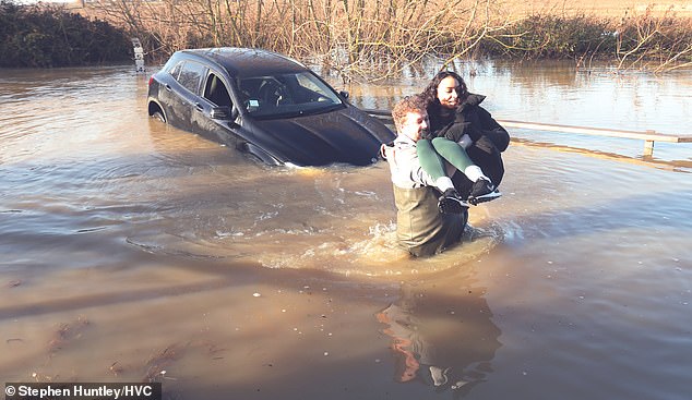 Auf dem Bild ist eine Frau zu sehen, die in Essex aus fast 1,2 Meter tiefem Wasser aus ihrem Auto gerettet wird