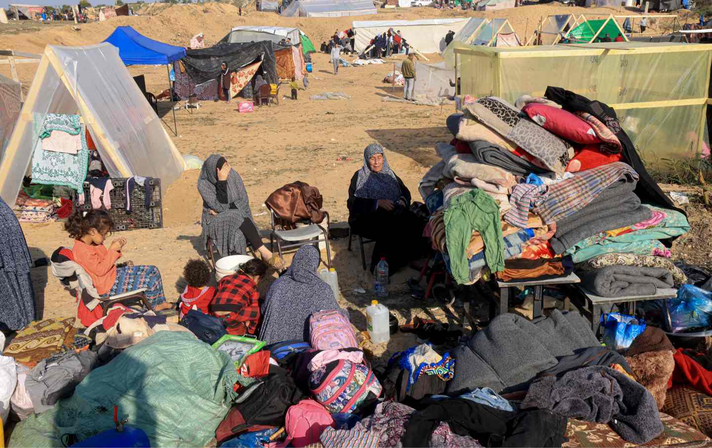 Vertriebene Palästinenser, die vor Khan Yunis geflohen sind, sitzen am 4. Dezember 2023 mit ihrem Hab und Gut vor provisorischen Unterkünften in Rafah im südlichen Gazastreifen.