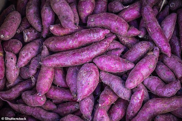 Lila Lebensmittel erfreuen sich bei Gesundheitsbewussten großer Beliebtheit, da sie entzündungshemmende Anthocyane enthalten.  Im Bild: Haufen lilafarbener Süßkartoffeln auf dem Gemüsemarkt