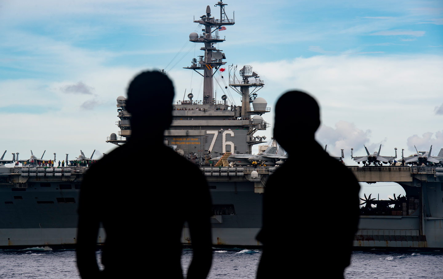 Matrosen beobachten, wie die Carrier Strike Groups USS Nimitz und USS Ronald Reagan als Nimitz Carrier Strike Force in Formation dampfen.