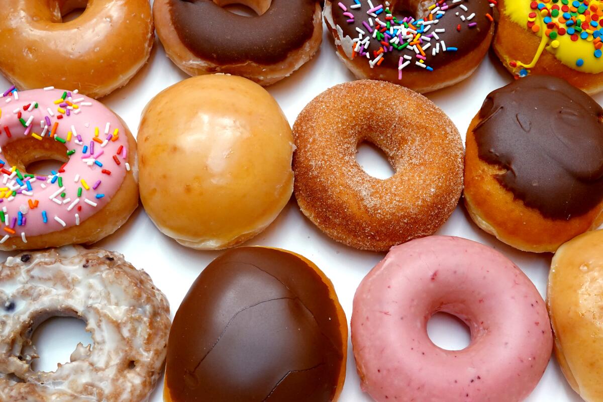 Eine Auswahl an Donuts, darunter rosa gefrostete und schokoladenglasierte