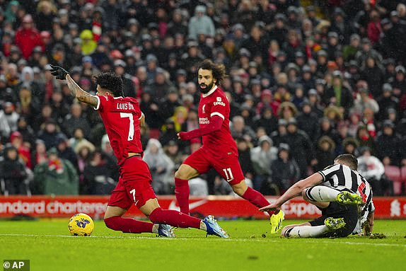 Liverpool's Luis Diaz, left, duels for the ball with Newcastle's Sven Botman during the English Premier League soccer match between Liverpool and Newcastle, at Anfield stadium in Liverpool, England, Monday, Jan. 1, 2024. (AP Photo/Jon Super)