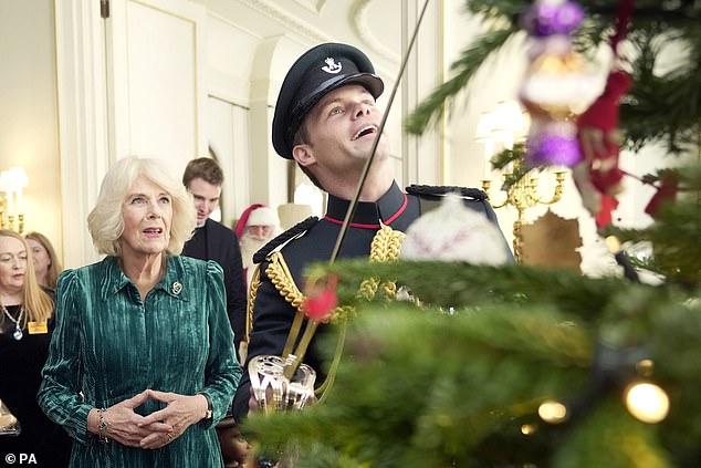 Equerry Major Ollie Plunket embellished the tree further and placed a decoration using his sword - a Christmas tradition that occurs each year at Clarence House