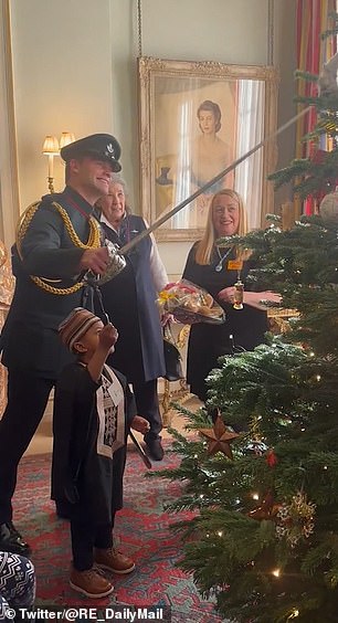 Equerry Major Ollie Pinkett appeared very pleased as he managed to place the decoration on the tree using the tip of his sword