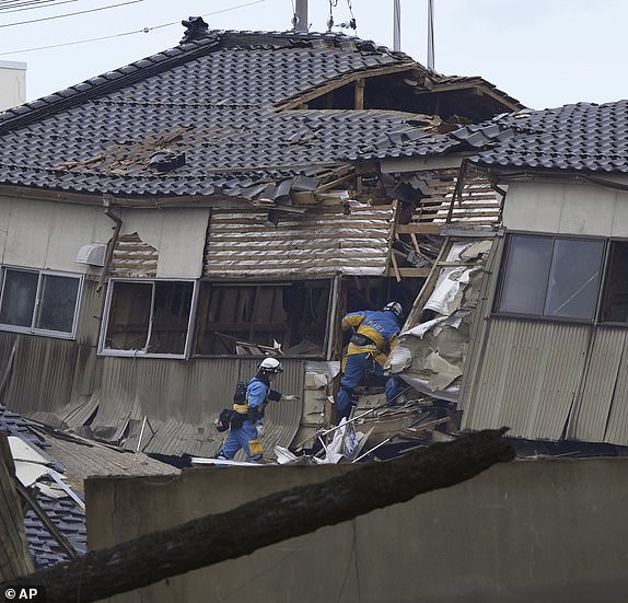 Police officers conduct a search operation at a destroyed house following an earthquake in Wajima, Ishikawa prefecture, Japan Tuesday, Jan. 2, 2024. A series of powerful earthquakes hit western Japan, damaging buildings, vehicles and boats, with officials warning people in some areas on Tuesday to stay away from their homes because of a risk of more strong quakes. (Kyodo News via AP)