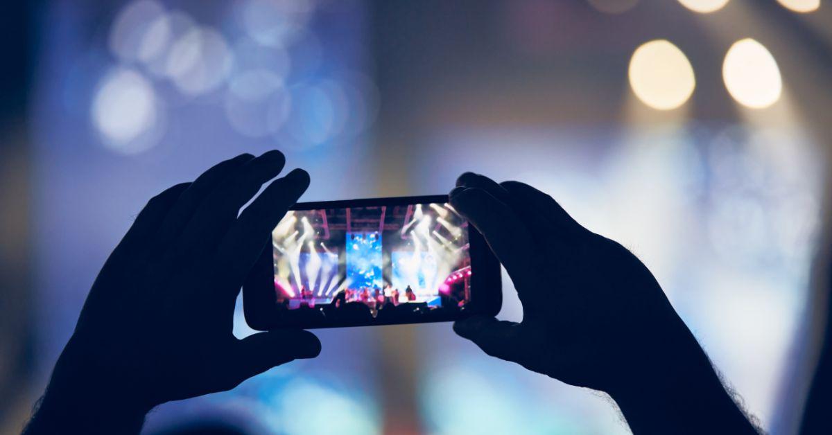 Eine Person benutzt ein Smartphone bei einem Konzert