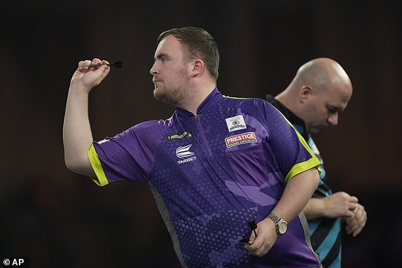 Luke Littler of England in action during the semifinal match against Scott Williams of England at the World Darts Championship, in London, Tuesday, Jan. 2, 2024. (AP Photo/Kin Cheung)
