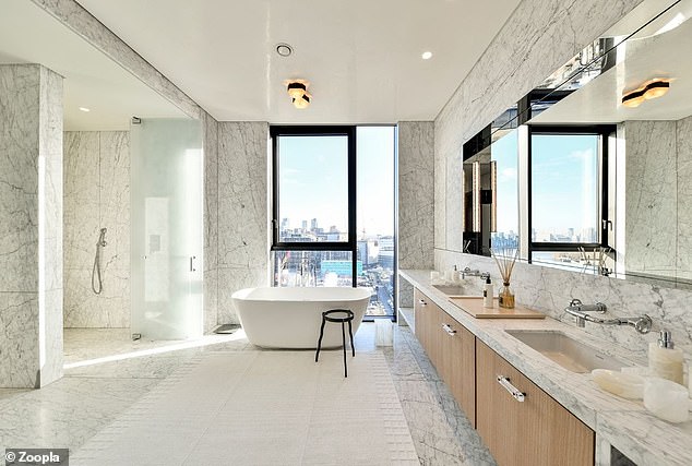 Dieses Badezimmer im Penthouse verfügt über eine Badewanne mit Blick auf die Skyline und raumhohen Marmor