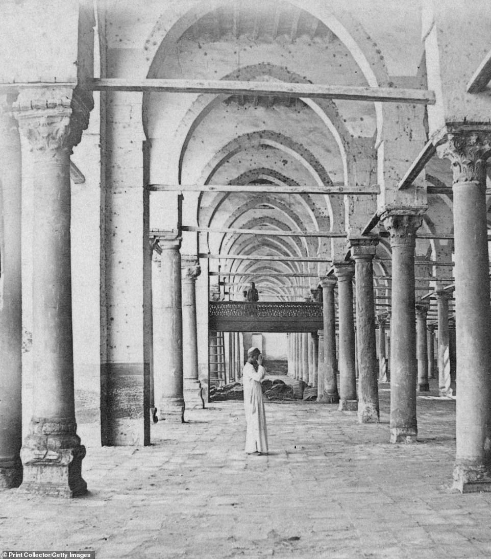 A worshipper is caught mid-prayer inside the beautiful decorated colonnade of the Amr ibn al-As Mosque in Cairo