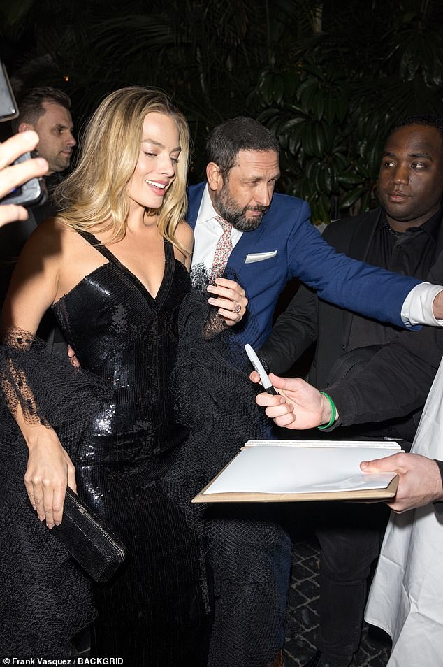 Margot is escorted to the afterparty following the Golden Globes ceremony