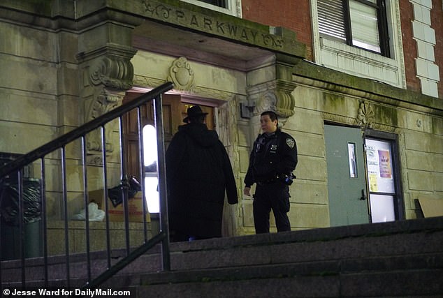 Am Montagabend wird ein NYPD-Beamter gesehen, wie er mit einem Mitglied der Gemeinde spricht