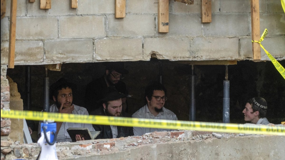 Jüdische Studenten sitzen hinter einer Bresche in der Wand einer Synagoge, die zu einem von den Studenten gegrabenen Tunnel in New York führte.