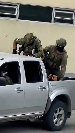 As the military carries out its orders to crack down on the violence in Ecuador, a clip (pictured) appeared to show an armed Ecuadorian soldier kicking a man, thought to be a suspected gangster, repeatedly in the head while in the back of a truck