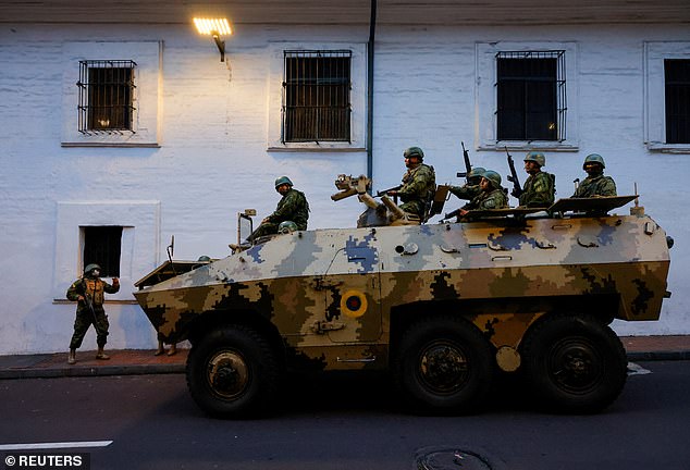 Soldiers in an armoured vehicle patrol the city of Quito's historic centre following an outbreak of violence on Tuesday