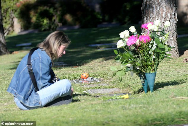 Kelly saß etwa 20 Minuten lang im Schneidersitz neben seinem Grabstein, bevor sie einen Anruf entgegennahm und zu ihrem Auto zurückkehrte