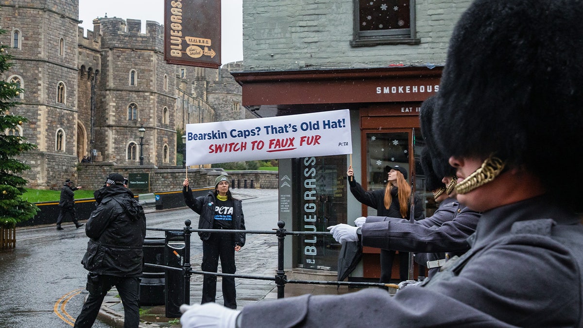 PETA-Unterstützer halten ein Banner mit der Aufschrift „Bärenfellmützen?“  Das ist ein alter Hut! 