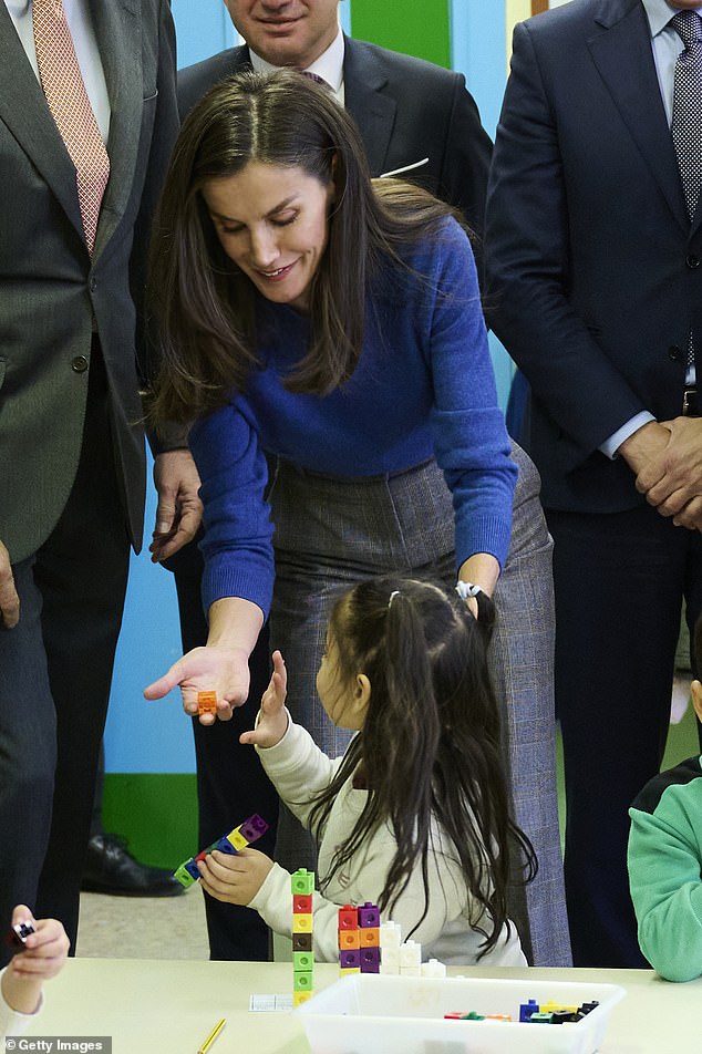Letizia played building blocks with a young girl during the tour of Gumersindo Azcarate School