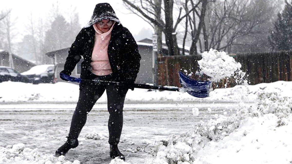 Eine Frau räumt in Arizona Schneebrocken weg