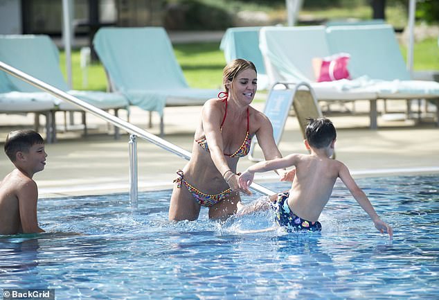Das 40-jährige Model erregte in dem mehrfarbigen Zweiteiler mit Paisleymuster Aufmerksamkeit, als sie ihre Waschbrettbauchmuskeln zur Schau stellte, während sie mit ihren Söhnen im Pool spielte