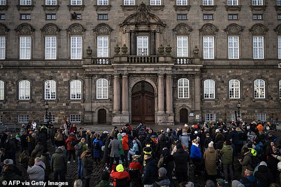 People gather in the early in the morning at Christiansborg Palace Square ahead of the proclamation of abdication of Denmark's Queen Margrethe II, in Copenhagen, Denmark, on January 14, 2024. Denmark turns a page in its history on January 14 when Queen Margrethe abdicates and her son becomes King Frederik X, with more than 100,000 Danes expected to turn out for the unprecedented event. (Photo by Jonathan NACKSTRAND / AFP) (Photo by JONATHAN NACKSTRAND/AFP via Getty Images)