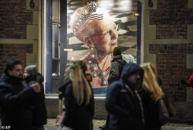 Menschen passieren ein Bild von Königin Margrethe in Kopenhagen, Dänemark, bevor sie am Sonntag den Thron an ihren Sohn übergibt