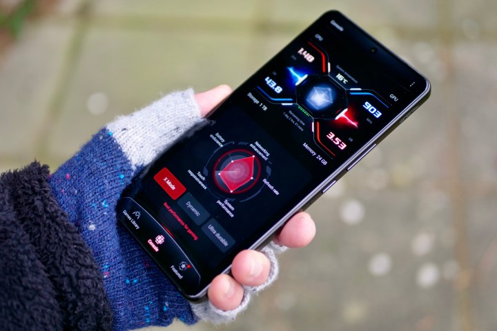A person holding the Asus ROG Phone 8 Pro, with the X Mode screen showing.