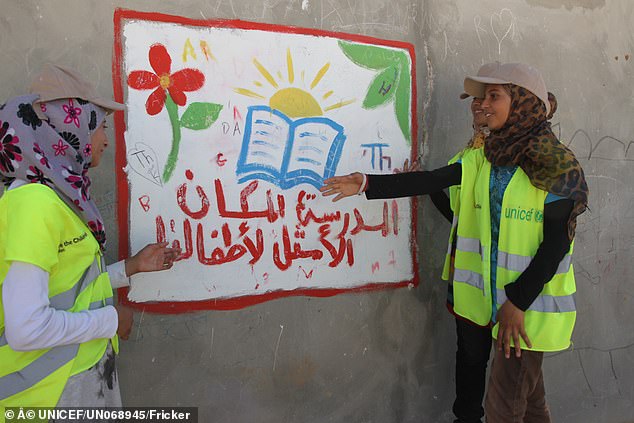 Während er im Flüchtlingslager Za'atari lebt, zeigt ein 14-jähriger Muzoon auf ein Schild, das die Bedeutung von Schule und Lernen hervorhebt