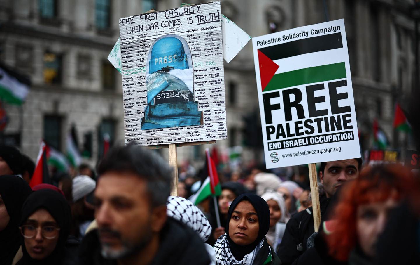 Pro-palästinensische Aktivisten und Unterstützer tragen Plakate, darunter ein Schild mit den Namen von Journalisten, die während des jüngsten Konflikts verletzt wurden, während eines Nationalen Marsches für Palästina im Zentrum von London am 13. Januar 2024.
