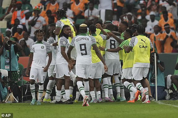 Nigeria players celebrate after William Troost-Ekong scored his side's opening goal during the African Cup of Nations Group A soccer match between Ivory Coast v Nigeria at the Olympic Stadium of Ebimpe, Abidjan, Ivory Coast, Thursday, Jan. 18, 2024. (AP Photo/Sunday Alamba)