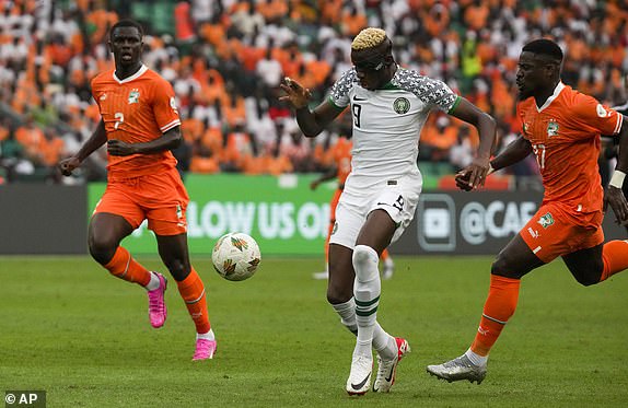 Nigeria's Victor Osimhen, centre, is challenged by Ivory Coast's Ousmane Diomande, left, during the African Cup of Nations Group A soccer match between Ivory Coast v Nigeria at the Olympic Stadium of Ebimpe, Abidjan, Ivory Coast, Thursday, Jan. 18, 2024. (AP Photo/Sunday Alamba)