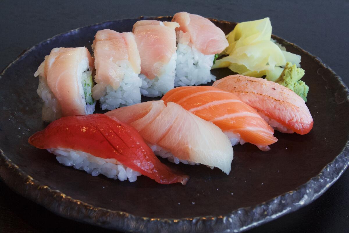 Eine horizontale Nahaufnahme eines Sushi-Mittagessens im Ikigai auf einem schwarzen Teller.