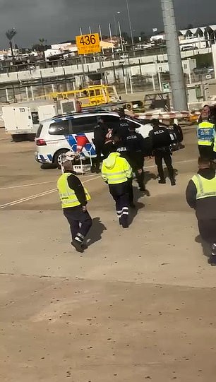 Nachdem er aus dem Flugzeug gezerrt worden war, wurde die Abführung des Mannes durch die örtliche Polizei gefilmt