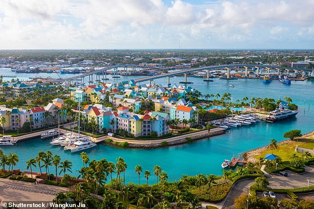 The Carnival Glory cruise liner passes through harborside villas in Nassau, Bahamas, during its three-day sail