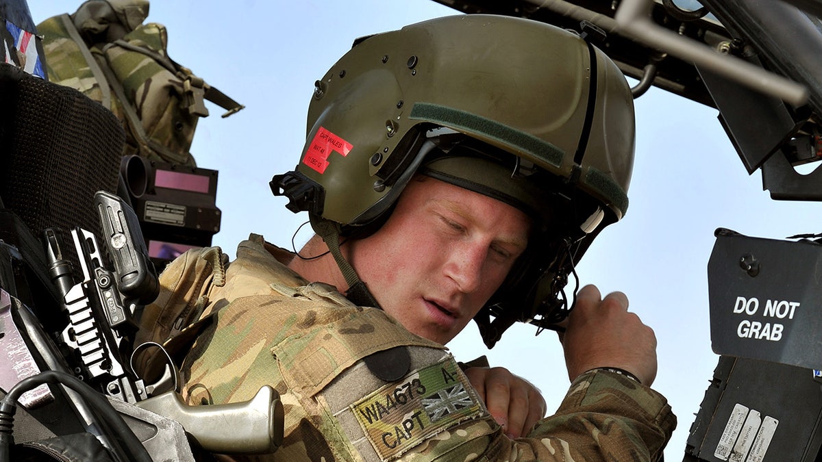 Eine Nahaufnahme von Prinz Harry in Militäruniform und Helm in einem Hubschrauber