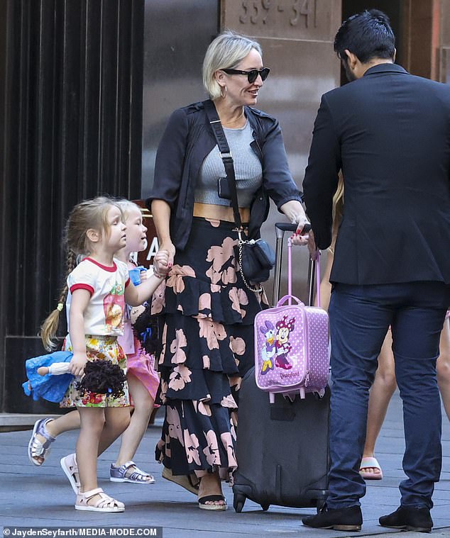 Währenddessen hielt die 46-jährige Fifi ihre Töchter Trixie (acht) und Daisy (zwei) bei sich, während sie die Hand ihrer Jüngsten hielt, während sie ihre Taschen belud
