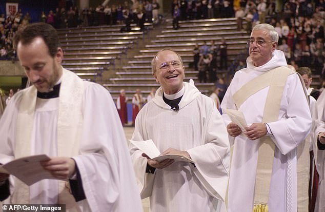 Rev. Gene Robinson (Mitte) lächelt dem Publikum während der Eröffnungsprozession seiner Weihe als Bischofskoadjutor der Episcopal Diocese of New Hampshire zu
