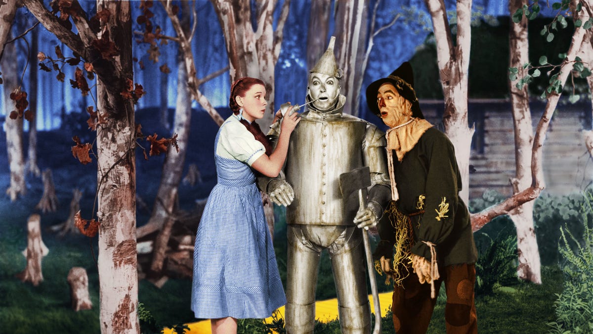 Judy Garland herein "Der Zauberer von Oz," neben dem Blechmann und der Vogelscheuche stehen