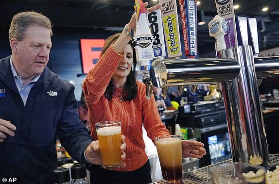 Republican presidential candidate former UN Ambassador Nikki Haley, right, and N.H. Gov. Chris Sununu pour beers during a campaign stop at a restaurant, Monday, Jan. 22, 2024, in Concord, N.H. (AP Photo/Charles Krupa)