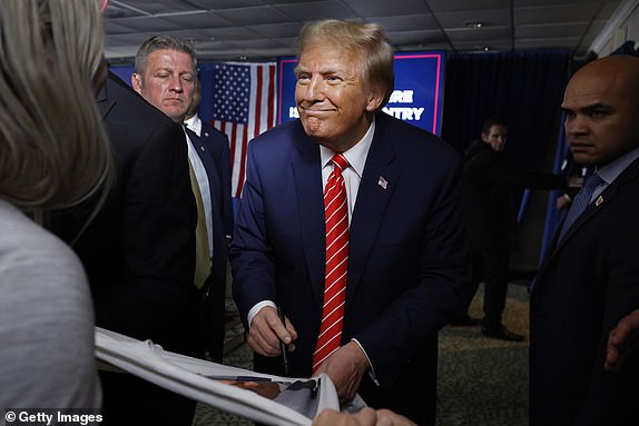 LACONIA, NEW HAMPSHIRE - JANUARY 22: Republican presidential candidate and former President Donald Trump signs autographs and shakes hands with supporters at the conclusion of a campaign rally in the basement ballroom of The Margate Resort on January 22, 2024 in Laconia, New Hampshire. Ramaswamy, Burgum and Scott all ran against Trump for the Republican presidential nomination but later dropped out and endorsed him. Trump is rallying supporters the day before New Hampshire voters will weigh in on the Republican nominating race with the first-in-the-nation primary. (Photo by Chip Somodevilla/Getty Images) *** BESTPIX ***