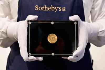 Ein Sotheby's-Mitarbeiter hält eine Double Eagle-Münze von 1933
