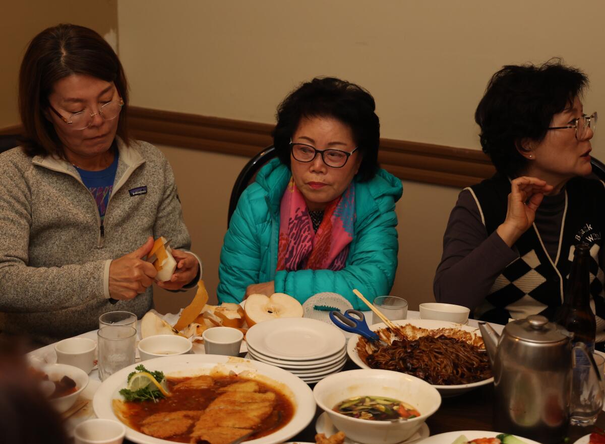 Drei Frauen sitzen an einem mit Essen beladenen Restauranttisch