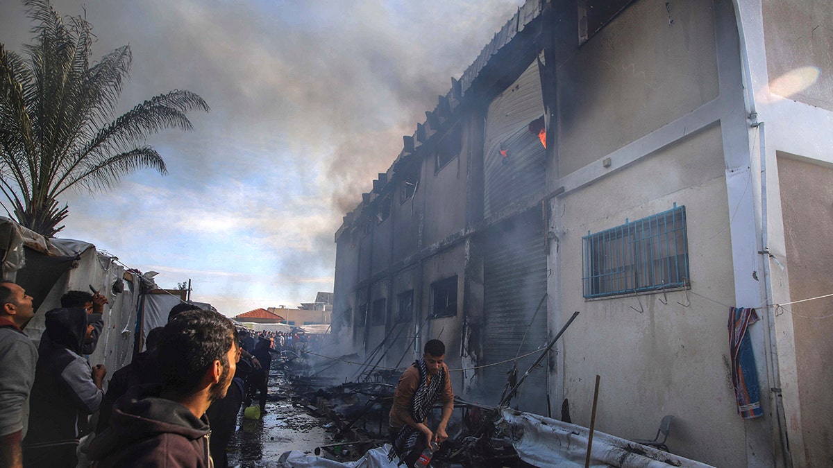 Palästinenser in der Nähe eines brennenden Gebäudes