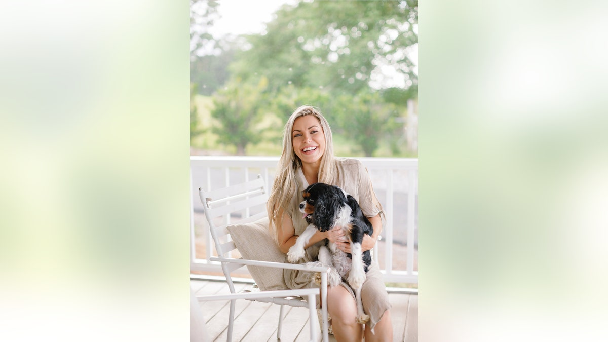 Crystal Hefner lächelt und hält ihren Hund