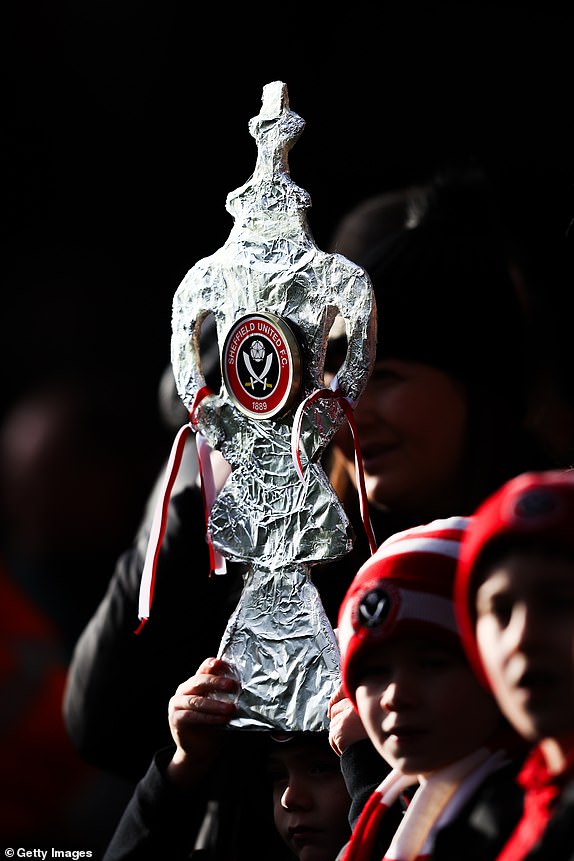 SHEFFIELD, ENGLAND - JANUARY 27: A tinfoil FA Cup trophy is seen in the hands of Sheffield United supporter during the Emirates FA Cup Fourth Round match between Sheffield United and Brighton & Hove Albion at Bramall Lane on January 27, 2024 in Sheffield, England. (Photo by James Gill - Danehouse/Getty Images)