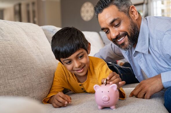 Vater und Sohn legen Geld in ein Sparschwein