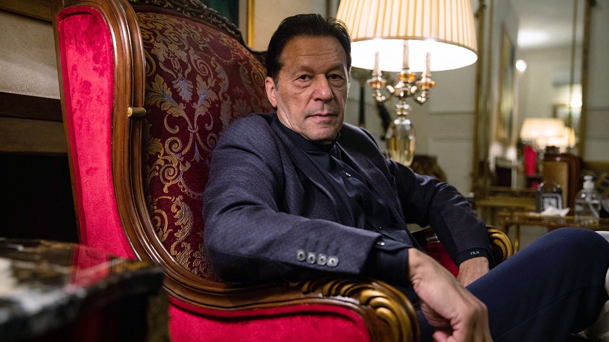 Khan sitzt auf einem Stuhl