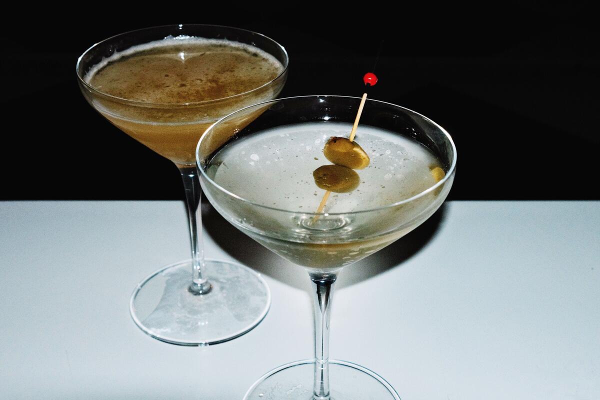 Zwei Cocktails in Coupé-Gläsern, einer mit Olivengarnitur